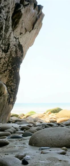 Duschrückwand - Steinstrand zwischen Felsen an Küste