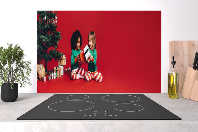 Spritzschutz - Fröhliche Kinder tauschen Weihnachtsgeschenke aus